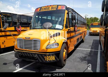 row of empty thomas built buses type c thomas saf-t-liner c2 yellow school busses bluebird bus in the background kissimmee florida usa Stock Photo