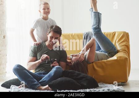 Smiling child. Young couple with kid looking together at the pictures maked by camera Stock Photo