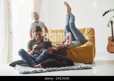 Easy conversation. Young couple with kid looking together at the pictures maked by camera Stock Photo