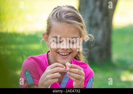 Portrait of a girl who knits on a knitting needles on a picnic in nature, close-up Stock Photo