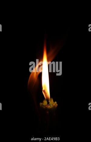 One light candle burning brightly in the black backgrounds Stock Photo