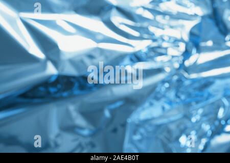 Crumpled colorful foil background. Abstract pattern with shadow. Neon classic blue color. Stock Photo