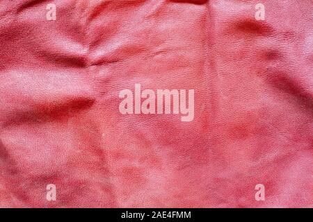 Color fabric texture. Red crumpled leatherette. A lot of creases and scuffs. Copy space. Stock Photo