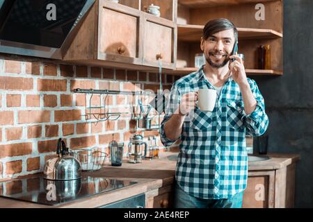 Joyful positive man talking on the phone Stock Photo