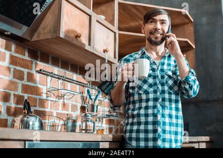 Positive man standing in the kitchen Stock Photo
