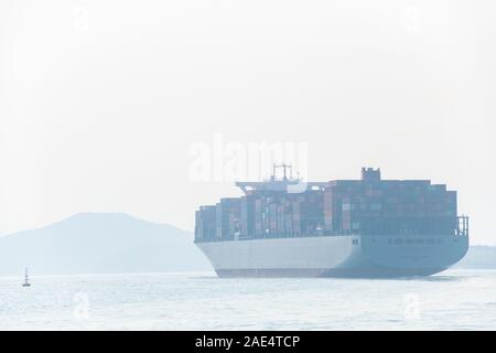 A huge, industrial ship in the shipping lanes outside Aberdeen Harbour in Hong Kong, China where three major shipping lanes meet. Stock Photo