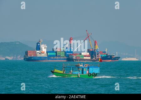 A huge, industrial ship in the shipping lanes outside Aberdeen Harbour in Hong Kong, China where three major shipping lanes meet. Stock Photo