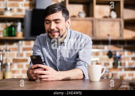 Smiling man using his smartphone Stock Photo