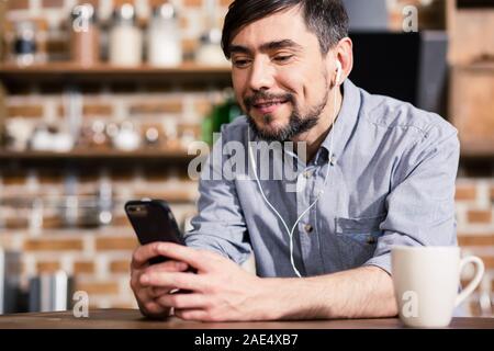 Cose up of positive man using his smartphone Stock Photo