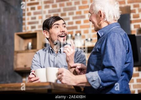 Cheerful man talking with his father in the kitchen Stock Photo