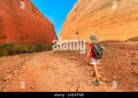 Backpacker walking towards entrance of Walpa Gorge in Uluru-Kata Tjuta National Park. Kata Tjuta and her domes is a culturally sensitive area. Outback Stock Photo