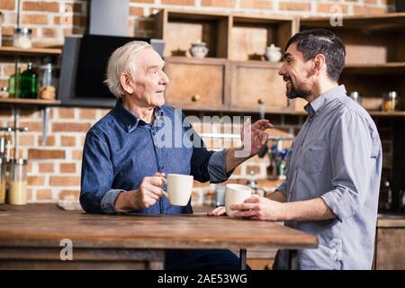 Pleasant aged man having a conversation with his son Stock Photo
