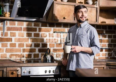 Nice bearded man drinking tea in the kitchen Stock Photo