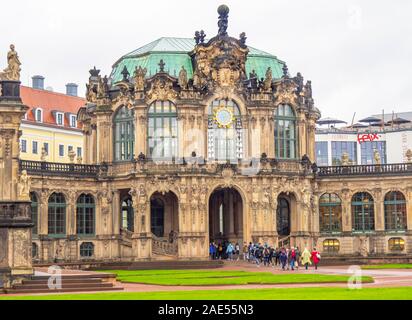 Tourists walking through archway of Baroque Glockenspiel Dresdner Zwinger Dresden Saxony Germany. Stock Photo