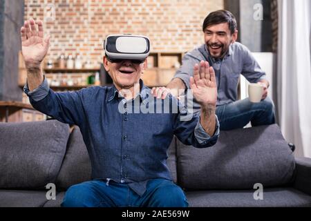 Cheerful elderly man using VR device Stock Photo