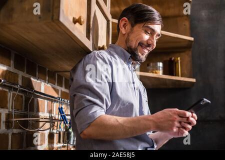 Joyful young man using his smartphone Stock Photo