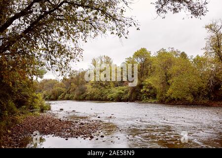 Walloomsac River surrounded by fall foliage near Burt Henry Covered Bridge in the New England town of Bennington, Vermont Stock Photo