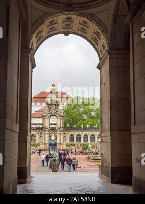 Tourists in Zwinger seen from Ornate and decorative entrance to the Semper Gallery Building wing of Zwinger Altstadt Dresden Saxony Germany. Stock Photo