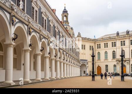 Tourists standing next to bronze pillars in the Stables Courtyard Royal Stallhof of Royal Palace Dresden Castle Altstadt Dresden Saxony Germany. Stock Photo