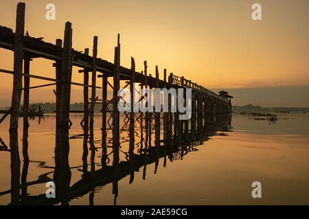 Sunrise view of the ancient teak wood U Bein Bridge that stretches across Taungthaman Lake at Amarapura, near the city of Mandalay in Myanmar (formerly called Burma) Stock Photo
