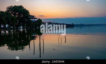 Sunrise view of the ancient teak wood U Bein Bridge that stretches across Taungthaman Lake at Amarapura, near the city of Mandalay in Myanmar (formerly called Burma) Stock Photo