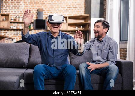 Elderly man using VR device with his son Stock Photo
