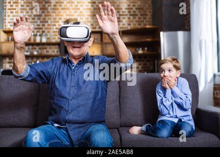 Smiling elderly man wearing VR glasses Stock Photo