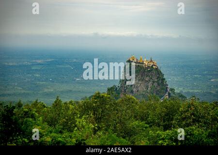View of Mt Popa, a volcanic outcrop near Bagan in Myanmar (Burma), topped with a golden temple shrine to Mahagiri Nat spirits Stock Photo