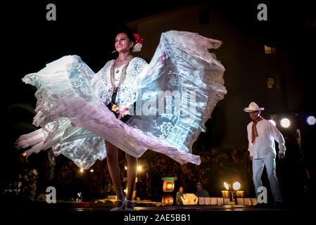 Two dancers perform La Bamba, a traditional Mexican dance symbolic of marriage. A beautiful woman dancer holds her skirt wide as she turns. Stock Photo