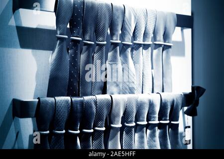 neckties showcase at store. Collection of coiled neckties in display and one flat necktie on top of others Stock Photo