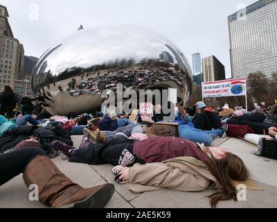 Chicago, Illinois, USA. 6th December 2019. Climate change protesters hold a 'die in' at Cloud Gate in Millennium Park during today's rally and march. Stock Photo