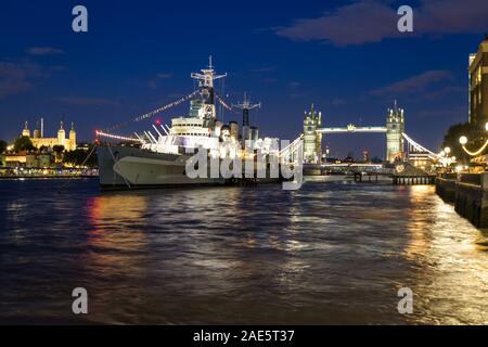 London  - September 05 2019: Evening view of the HSM Belfast on the Thames with the Tower Bridge in the background, London September 05,  2019