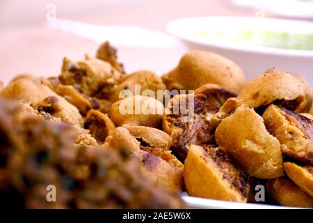 Crispy onion bhajis or kanda or pyaj ke pakore or pakoda , delicisous indian and brazilian street food on salad, typically enjoyed in rainy / monsoon Stock Photo