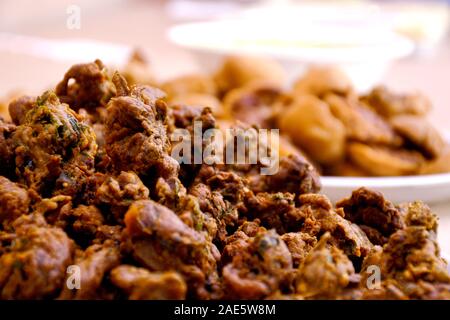 Crispy onion bhajis or kanda or pyaj ke pakore or pakoda , delicisous indian and brazilian street food on salad, typically enjoyed in rainy / monsoon Stock Photo