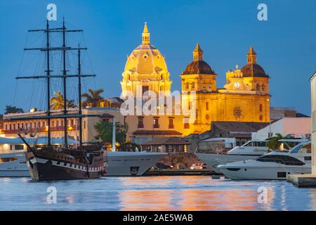 Dusk view of boats moored alongside the historic buildings of the walled old city of Cartagena in Colombia. Stock Photo