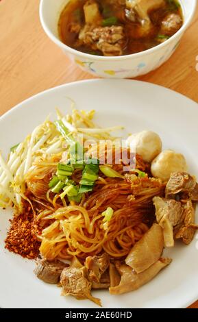 dried thin rice noodle topping braised pork and brown bone soup Stock Photo