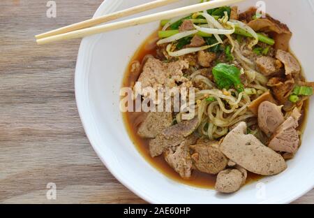 dried thin rice noodle topping braised pork and liver in brown soup Stock Photo