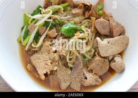 dried thin rice noodle topping braised pork and liver in brown soup Stock Photo