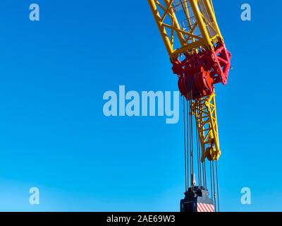 Part of yellow tower crane against blue sky. Stock Photo