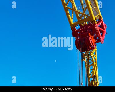 Part of yellow tower crane against blue sky. Stock Photo