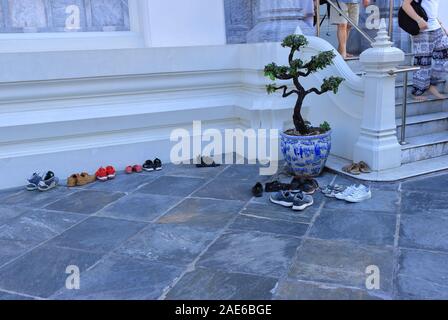 Bangkok, Thailand - December 2, 2019 : Shoes are taken off near tree pot before tourists enter ordination hall of Wat Pho, this is Thai tradition Stock Photo