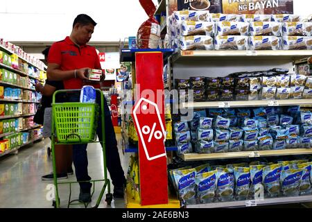Antipolo City, Philippines – December 4, 2019: Customer buying food and other products inside a grocery store. Stock Photo