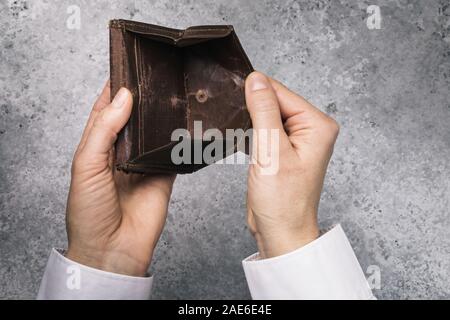 An open empty wallet in the hands of a man. Bankruptcy and lack of money concept Stock Photo