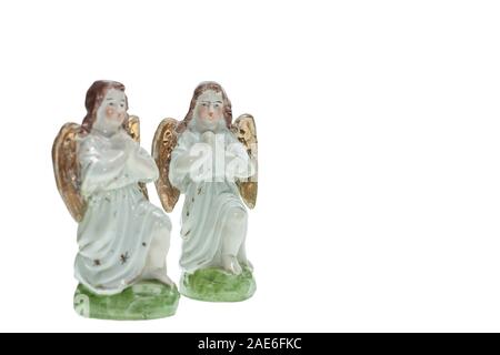 Two porcelain angels in a prayer pose isolated on a white background Stock Photo