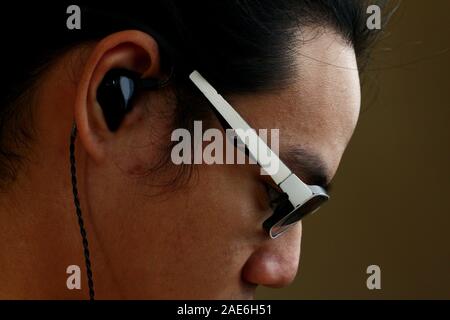 Close up side view photo of an Asian teen with eyeglasses and earphones Stock Photo