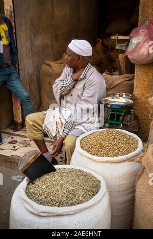 Ethiopia, Amhara Region, Gondar, Arada Market, trader sat by sacks of raw coffee beans Stock Photo