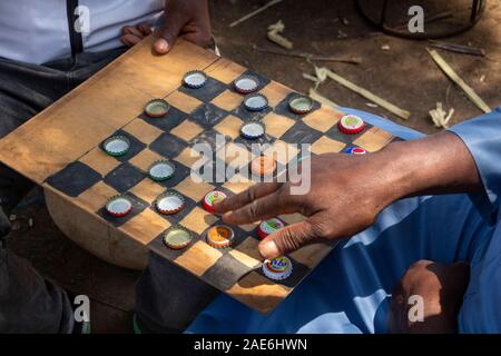 Ethiopia, Amhara Region, Gondar, Arada Market, hands of man playing draughts using beer bottle tops Stock Photo