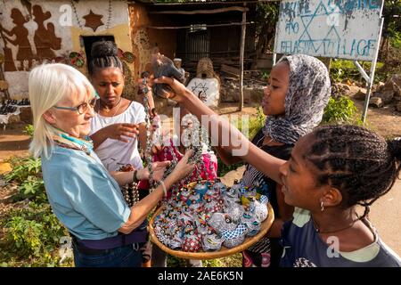 Ethiopia, Amhara Region, Gondar, Wolleka Falasha Jewish Village, children selling souvenirs to senior tourist Stock Photo