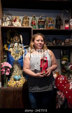 Posed photo of a devotee of a Santa Muerte in her home temple in Elmhurst, Queens, New York City. Stock Photo