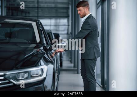 Opening the door. Modern stylish bearded businessman in the automobile saloon Stock Photo